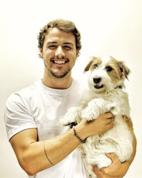 Stian Lauritzen holder hunden sin og smiler til kamera