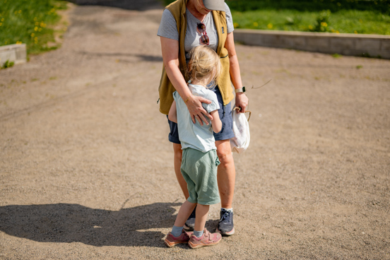 En voksen trøster et barn utendørs.