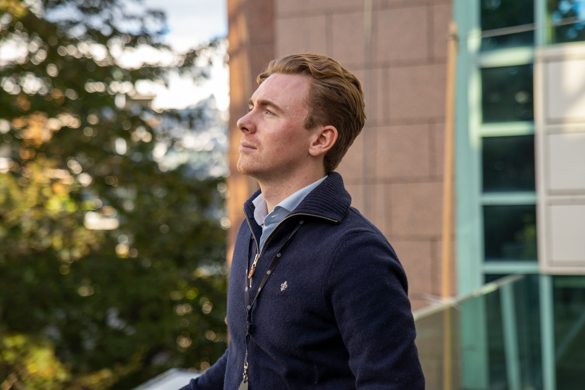 Linus står på takterassen på kontorbygget å ser ut mot byen.