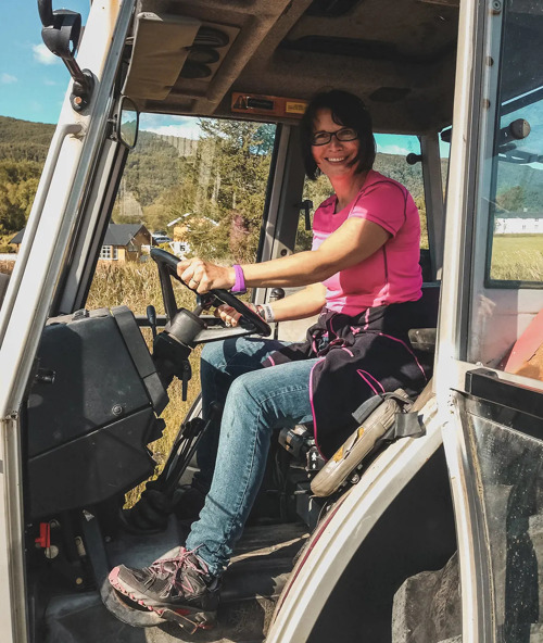 Solfrid Lind i traktor med rosa t-skjorte