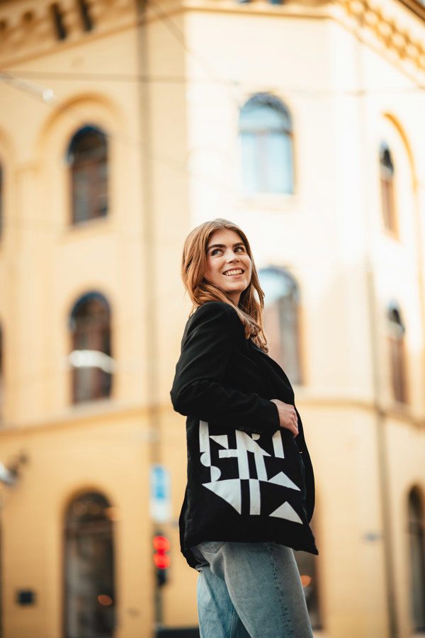 Kvinnelig student foran murbygg,