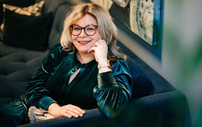 Rektor Trine Johansen Meza smiler til kamera, sittende i sofa.
