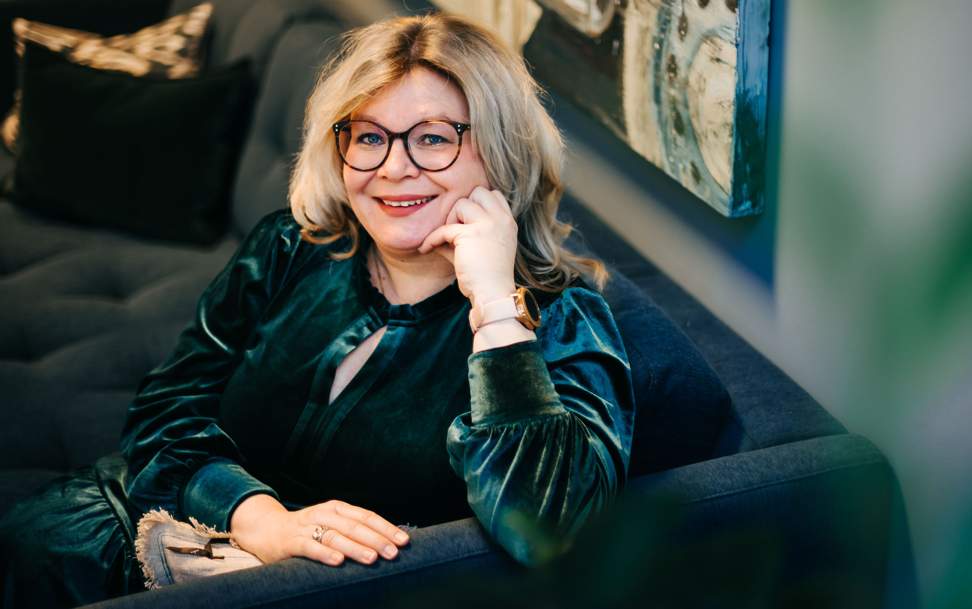 Rektor Trine Johansen Meza smiler til kamera, sittende i sofa.