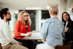 Det diskuteres rundt et bord, hvor fem voksne studenter er samlet