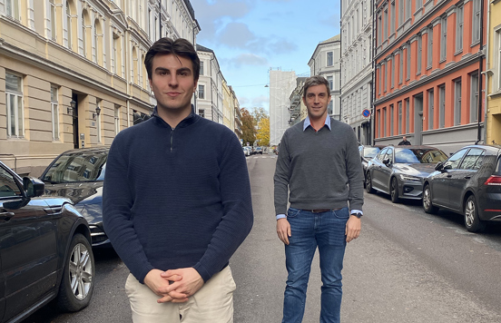 Foto av to unge menn som står i en gate.