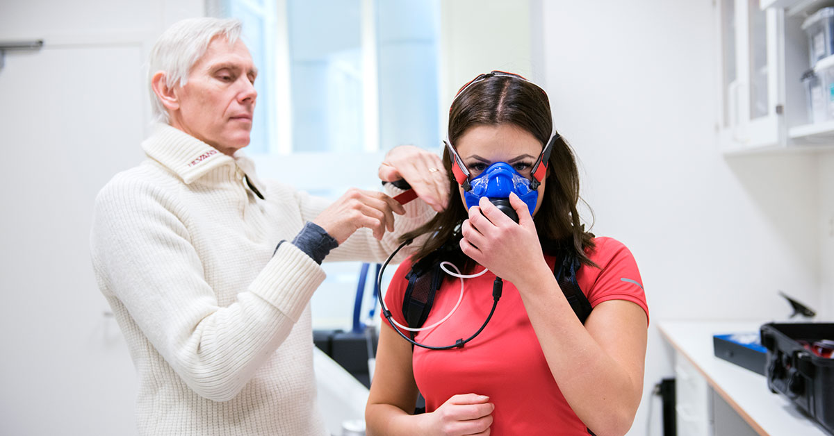 Bilde av helsepersonell som påfører en oksygenmålermaske på en pasient.