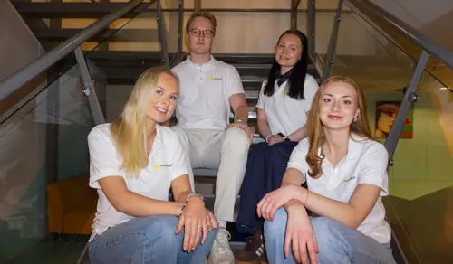 De fire innovasjonsstudentene bak Autodash sitter i trappen på Kristianias campus Bergen. 