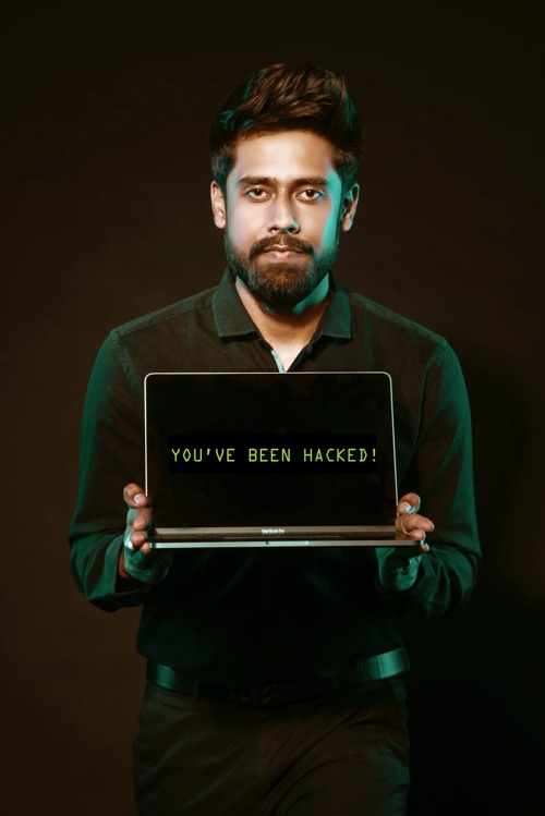 En mann som står med en pc hvor teksten sier "you've been hacked!"