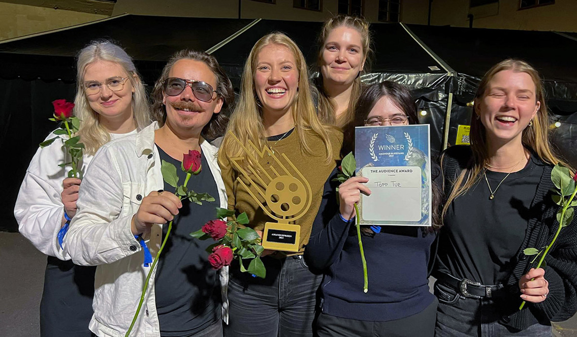 Foto av vinnerne av publikumsprisen under Amandus Blikkfang 2021, som holder frem en pokal og blomster.