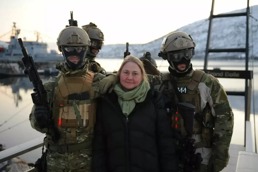 Antropolog Tone Danielsen står mellom tre maskerte soldater