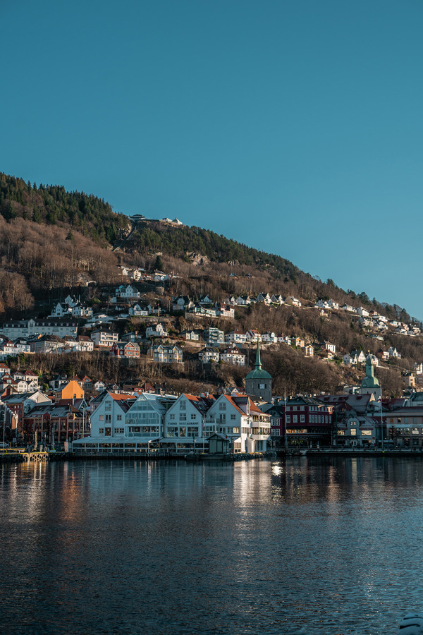 Bergen i strålende solskinn. Fjorden glitrer, himmelen er fri for skyer.