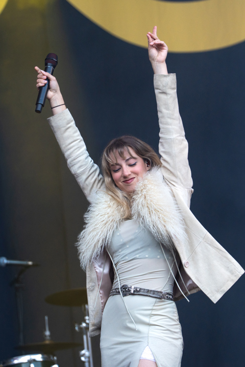 Artisten RABO står på scenen med mikrofon i hånden.