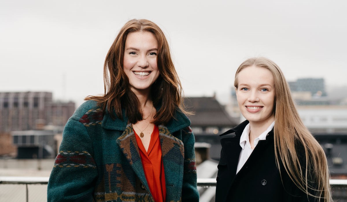 To unge kvinner står på taket på Høyskolen Kristiania