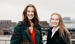 To unge kvinner står på taket på Høyskolen Kristiania