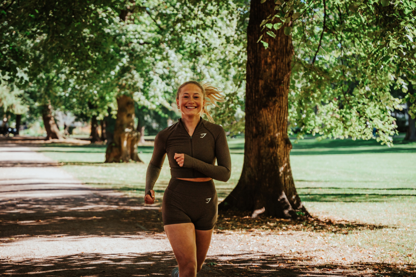 Ung student løper i park.