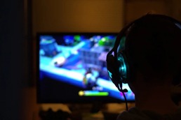 Boy sitting in front of a computer with gaming devices