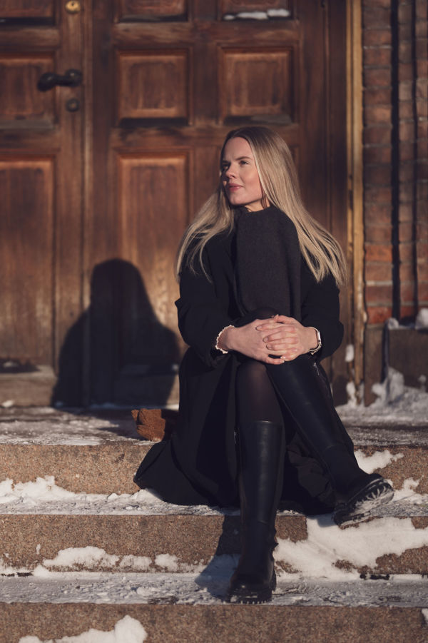 Zandra sitter utenfor Oslo domkirke en vinterdag.