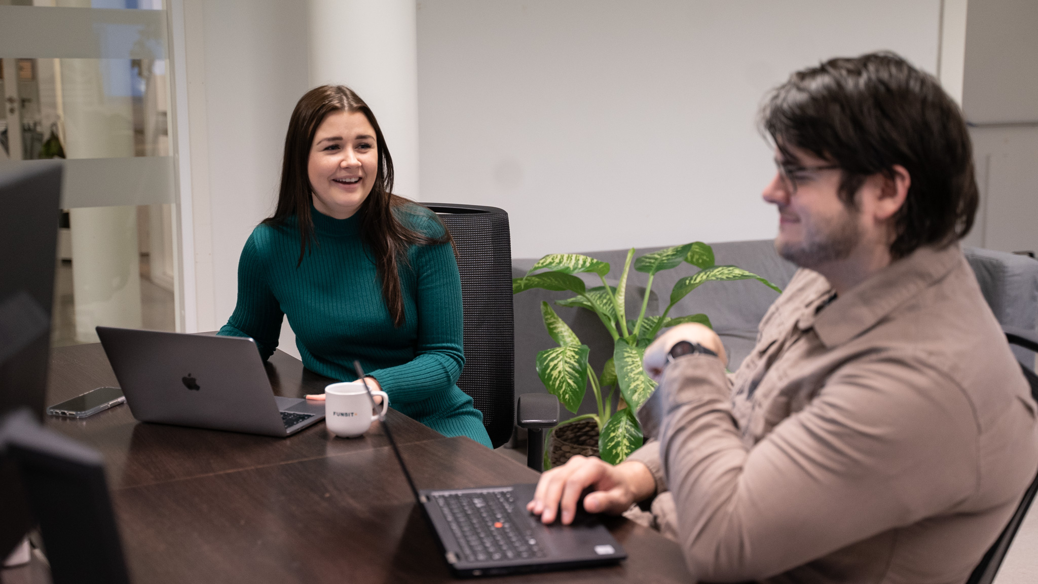 Emilie og kollega sitter ved en pult på funbitkontor