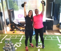 Personal trainer and her client smiling in the gym