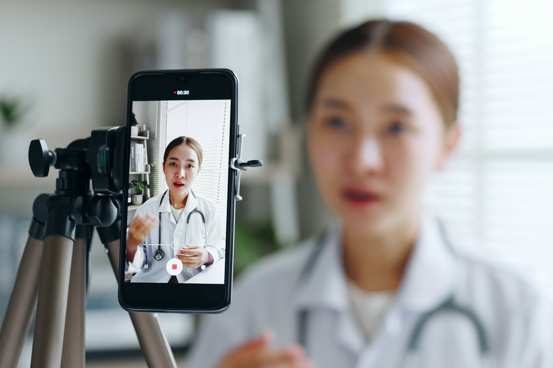 Female doctor recording video on smart phone