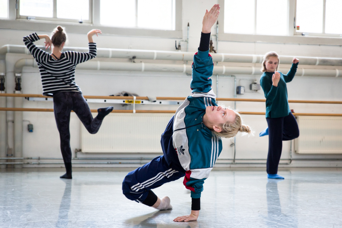 Bilde av tre kvinnelige dansere i et studio i hver sin positur.