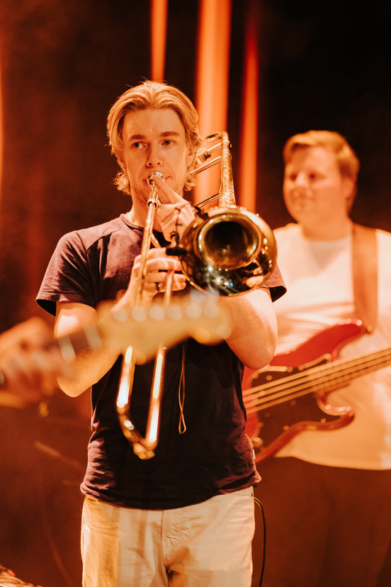 Trompetist og gitarist spiller på scene.