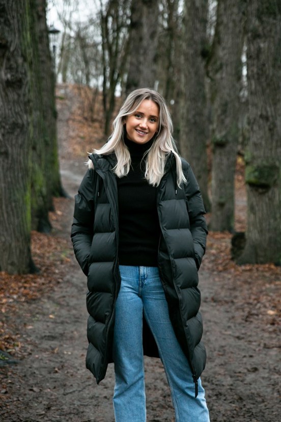 Kvinne som står i en skog,