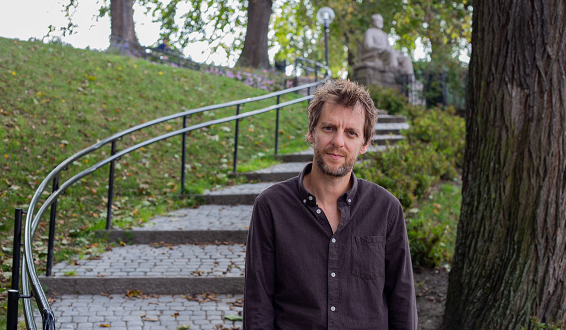 Thomas Haugesveen står foran en trapp i en park. 