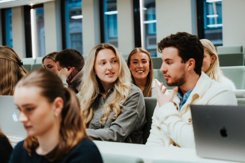 Studenter ved Kristiania samarbeider under forelesning.