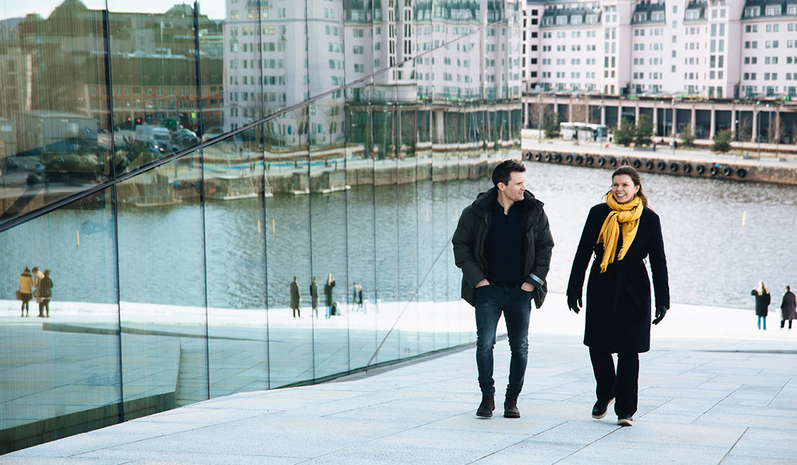To personer går oppover taket på operaen i Oslo.
