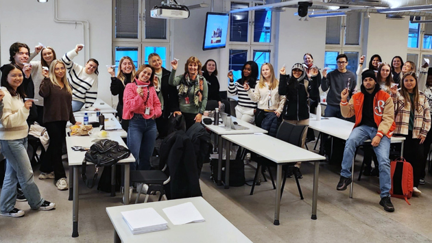 Foto av stor studentgruppe i klasserom.