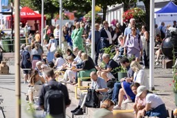 En gate i Arendalsuka med masse folk som sitter ute i solen