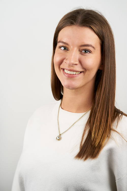Foto avkvinne som smiler til fotograf.