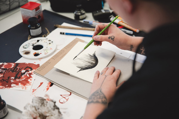 Student jobber med en illustrasjon. Fagskolestudiet Illustrasjon ved Høyskolen Kristiania.