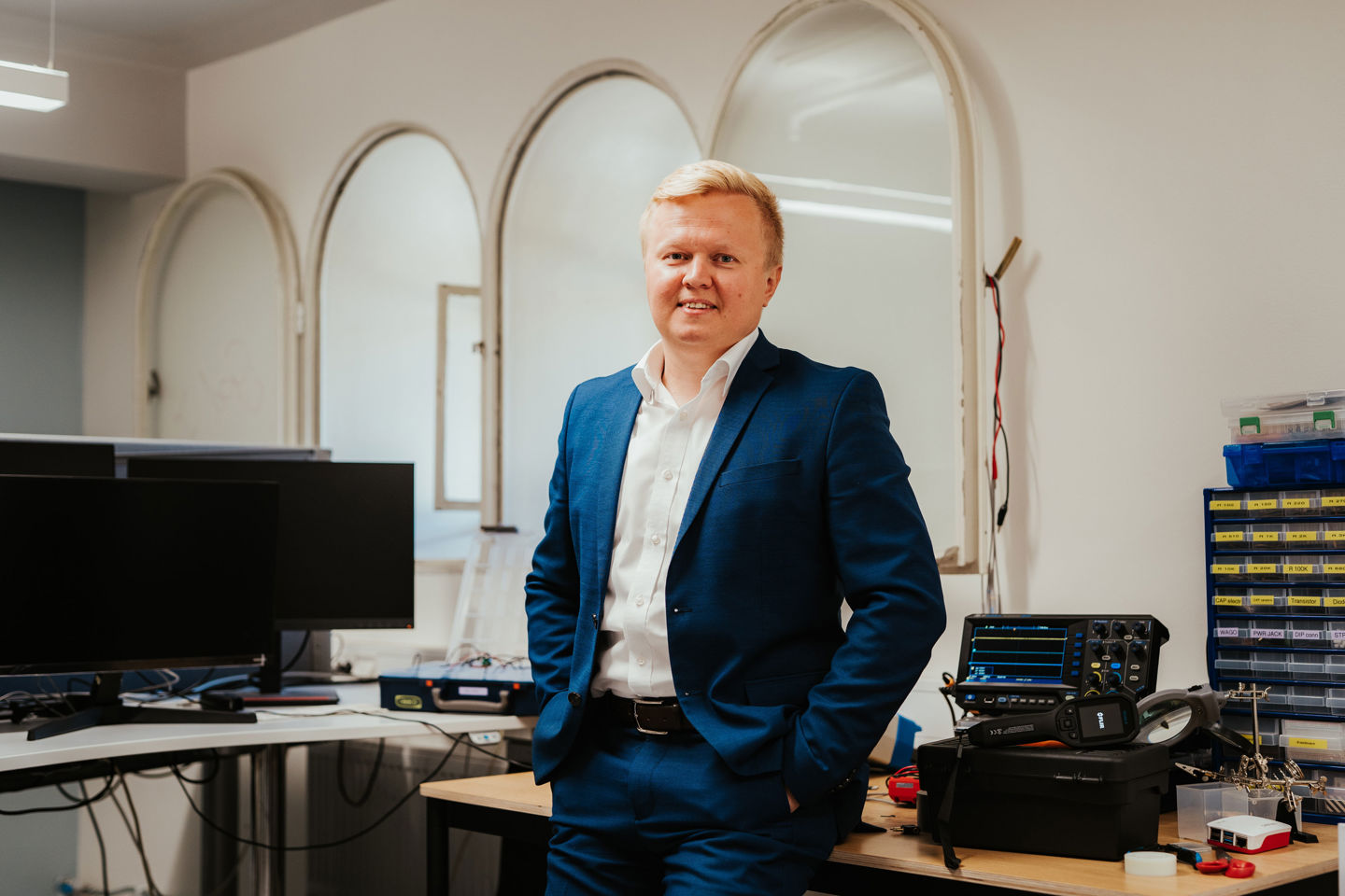 Førsteamanuensis Andrii Shalaginov poserer foran et bord med cybersikkerhetsutstyr
