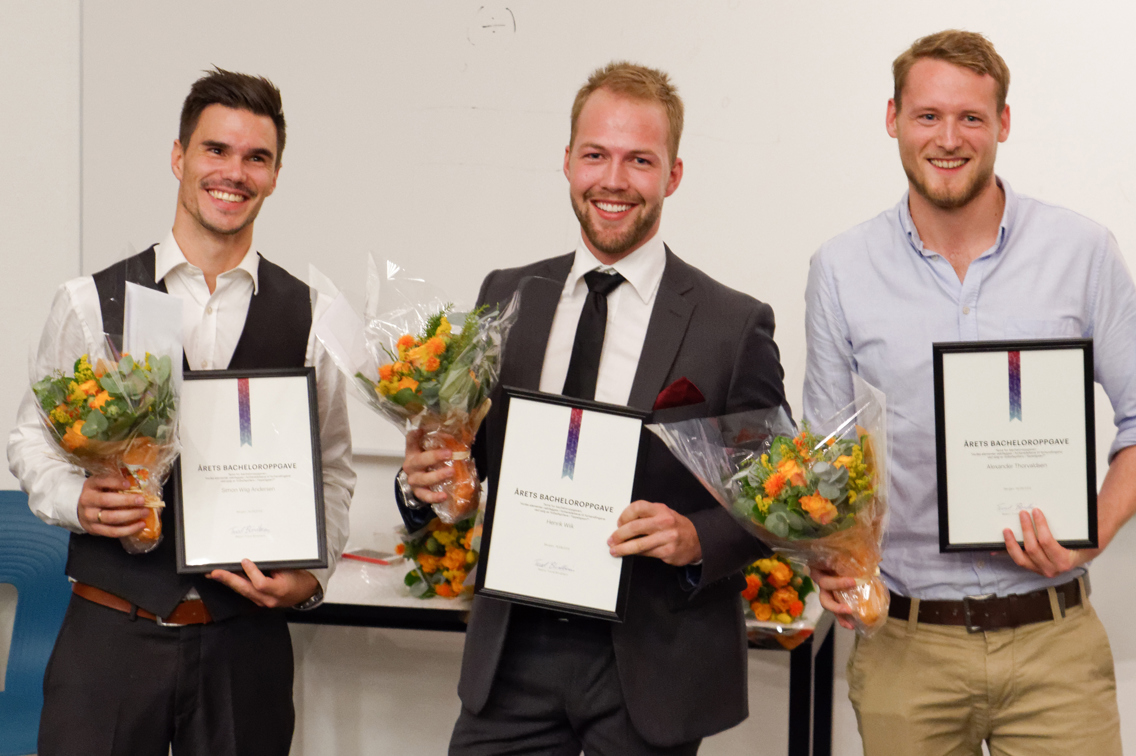 Foto av 3 mennesker som som holder buketter og diplomer.