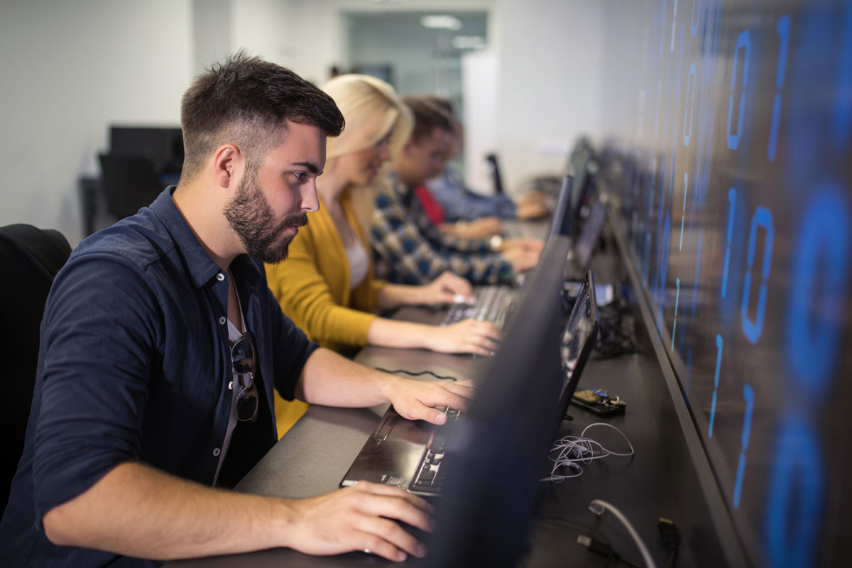 Studere teknologi. Her sitter det en gjeng og koder. Bilde: Istock. 