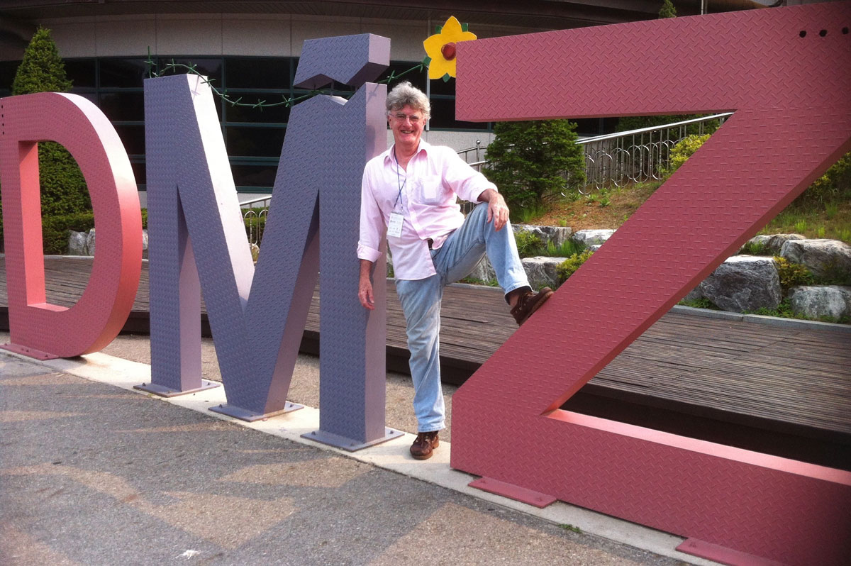 Man placed in the midst of three large letters – DMZ.