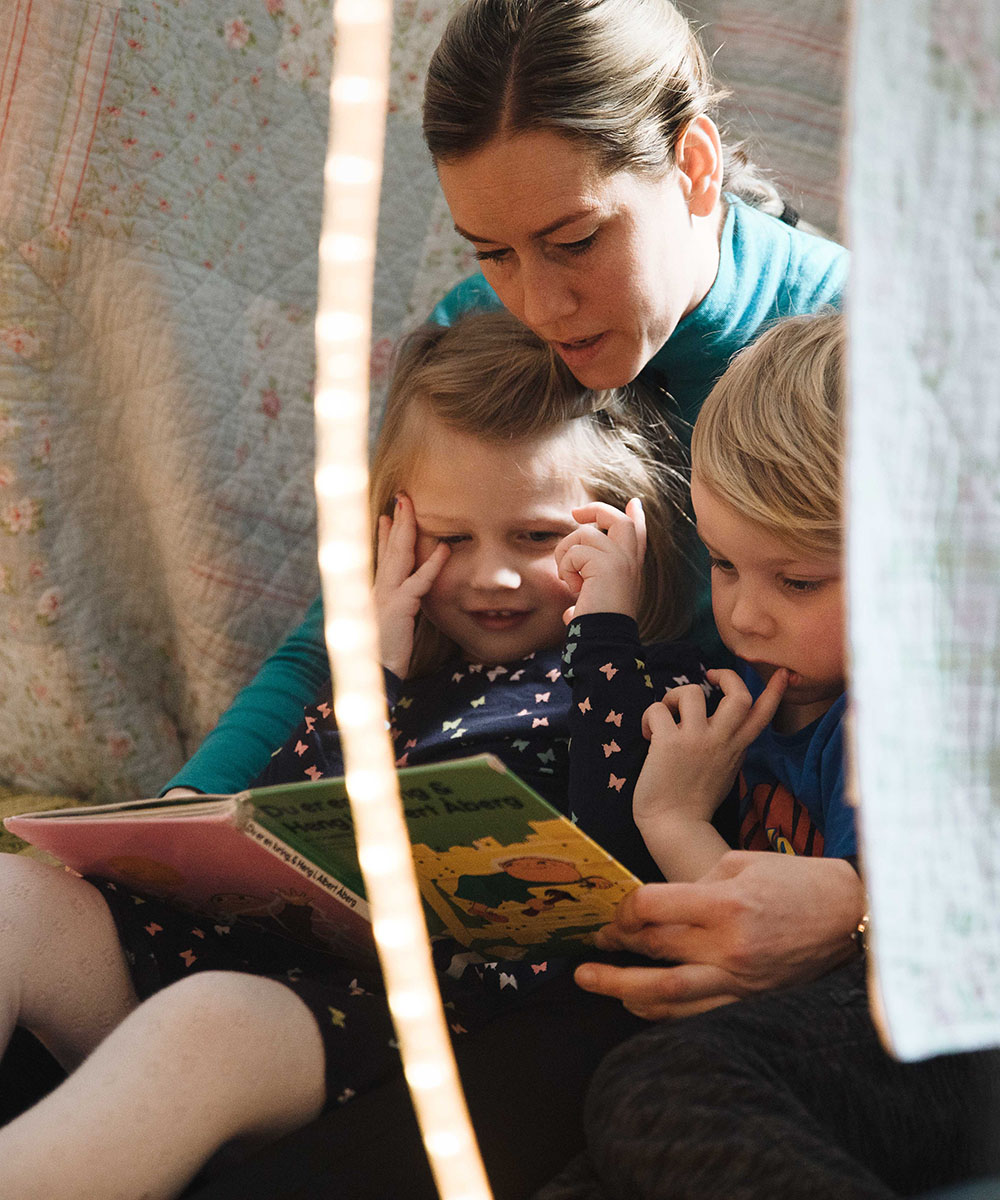 Nettstudent Ågot Iversen studerer Barn med særskilte behov på Fagskolen Kristiania. Her sitter hun sitter hun og leser en bok sammen med to barn i barnehagen.