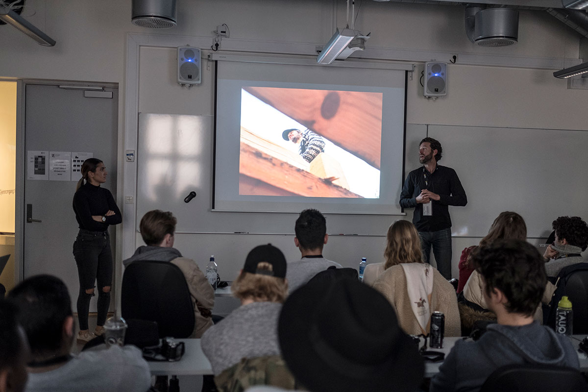 Et mørkt klasserom med studenter i forelesning om fotografi.