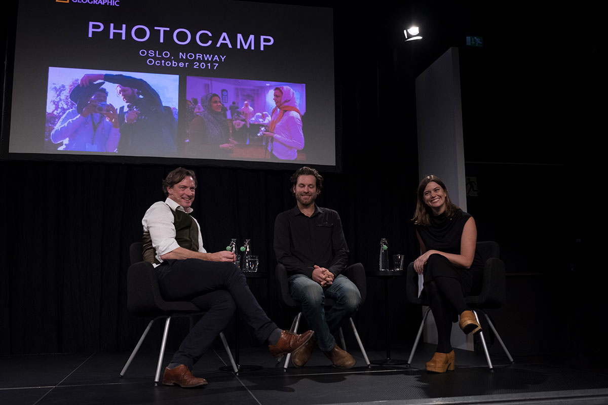 Tre kjente fotografer sitter på en scene under en av Photocamps paneldebatter