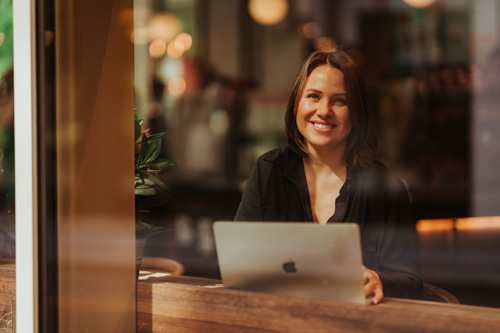 Bildelenke til nettstudier av kvinne med PC på kafé.