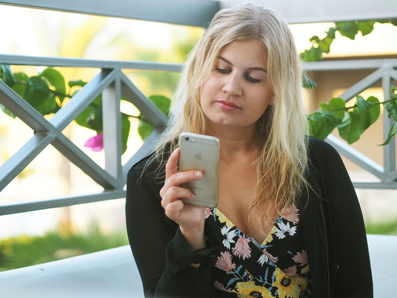 Ung kvinne som scroller på en iPhone