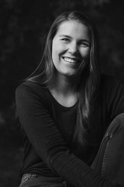 Portrett av student på Interaksjonsdesign ved Fagskolen Kristiania, Helene Høie Næsheim. Bildet er i svart og hvitt, og Helene smiler til kameraet.