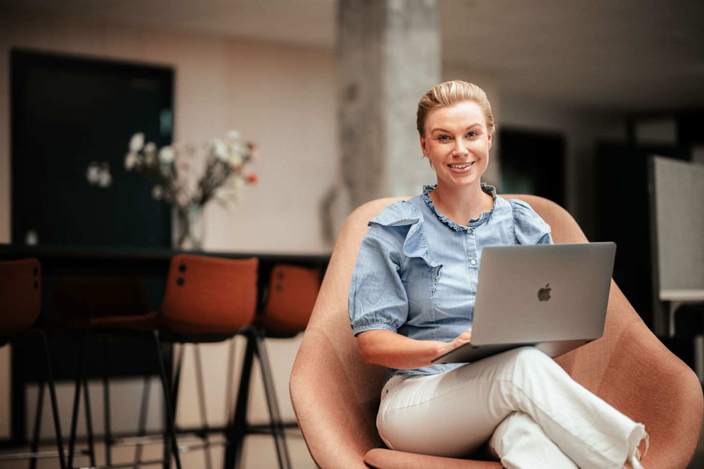 Nettstudent sitter i stol med PC på fanget.