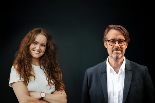 To nettstudenter poserer foran nøytral bakgrunn
