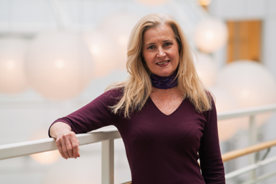 Dame i grønn kjole poserer for kamera.