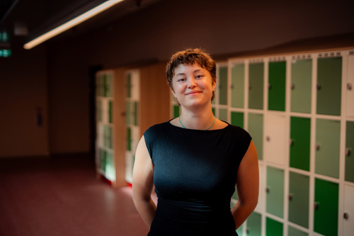 Kristiania-student i en gang foran låsbare skap.