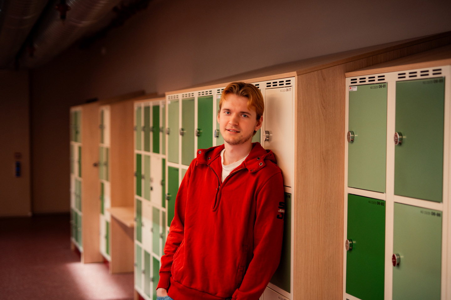Student står i en gang foran låsbare skap.