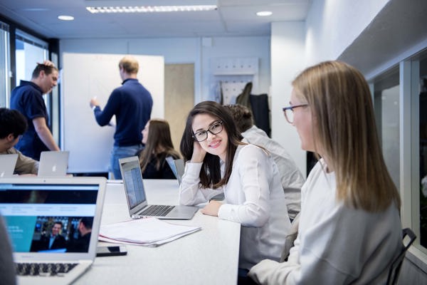 Foto av to kvinnelige studenter i et klasserom.